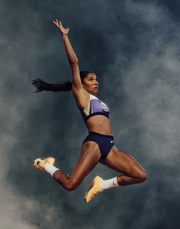 An athlete leaping against a cloudy sky