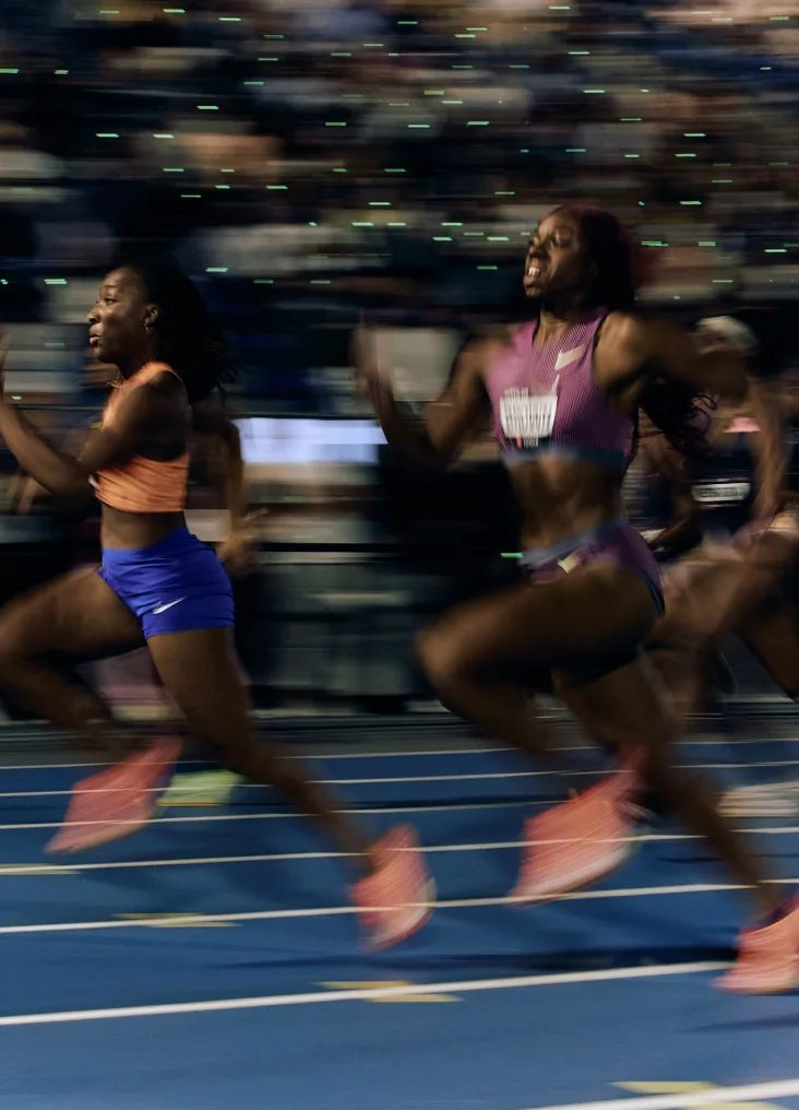 Sprinters racing down the blue track at ATHLOS NYC 2024